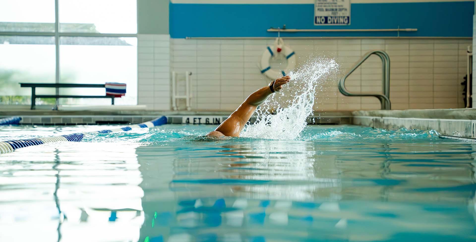 eos gym member swimming in eos branded lap pool