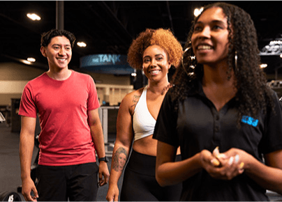 eos staff member giving a tour of the gym to two smiling guests