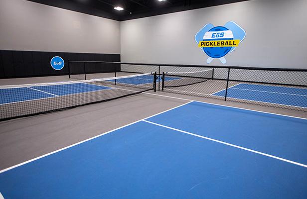 two empty indoor pickleball courts with eos branding