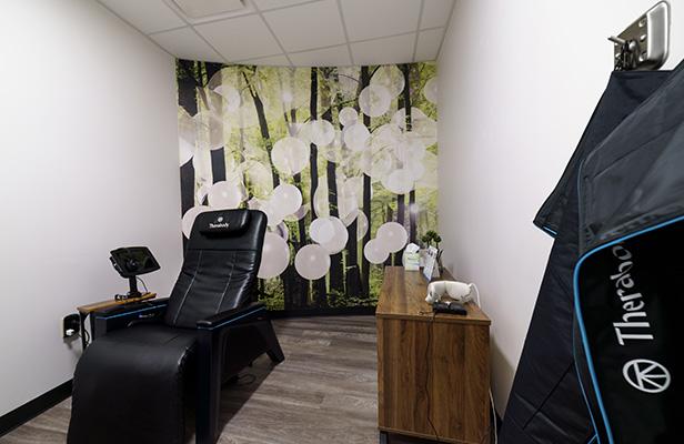 a massage chair in a white room with floral decorations