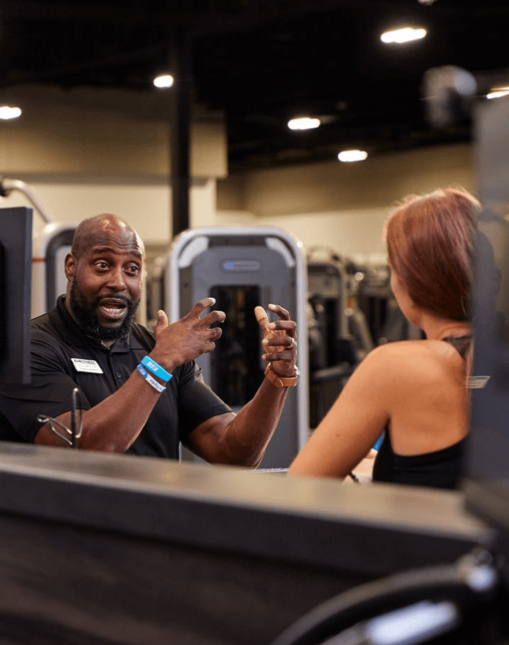 personal trainer explaining a workout to eos gym member inside of a eos branded box gym